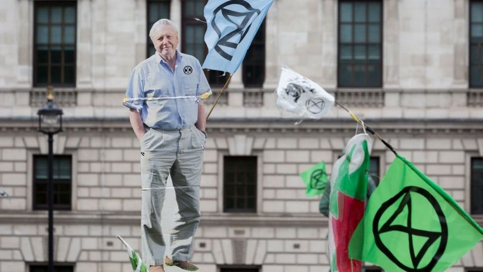 Una imagen de cartón de tamaño natural de David Attenborough es llevada por activistas de Extinction Rebellion durante una protesta en Londres en 2018