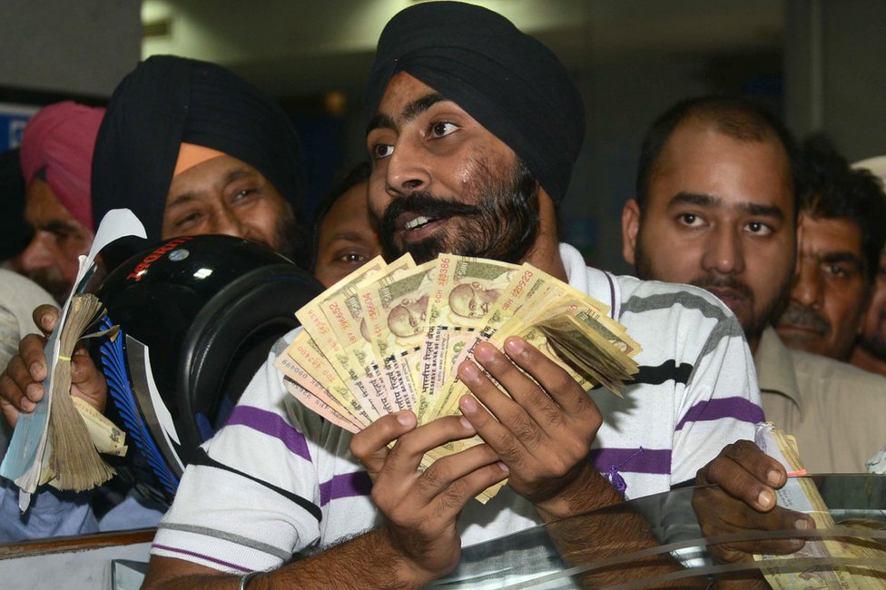 Клиенты индийских банков ожидают депонирования банкнот номиналом 500 и 1000 рупий в банке в Амритсаре 10 ноября 2016 г.