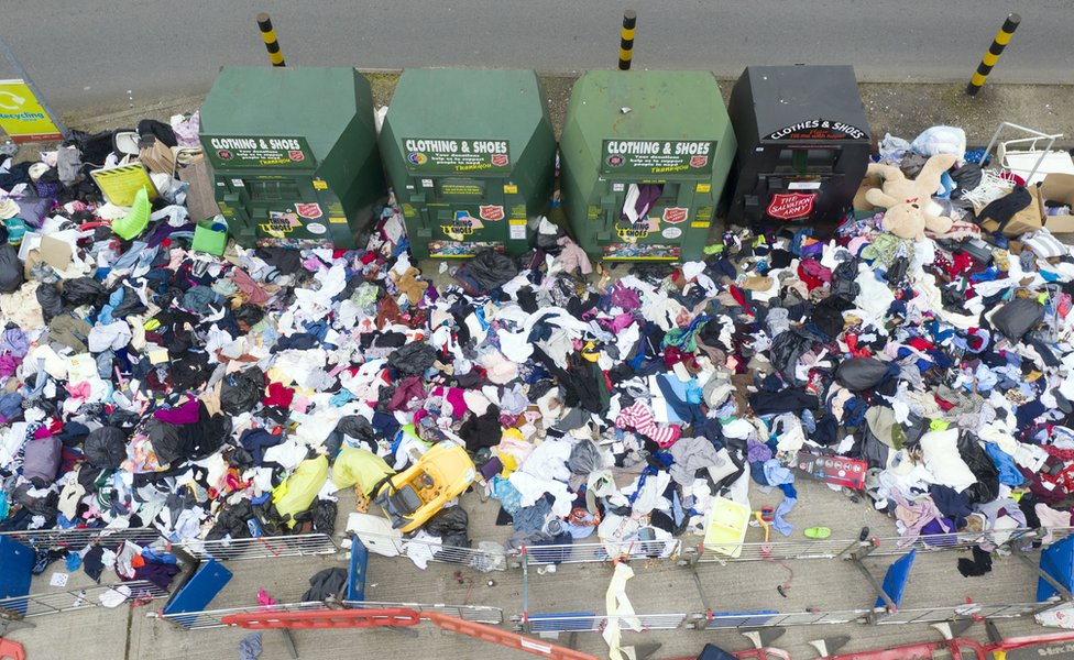 An aerial view of lots of rubbish discarded next to a recycling centre