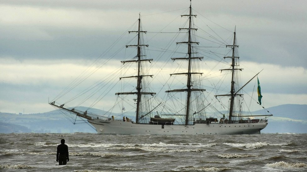 Рисунок из «Другого места» Энтони Гормли приветствует один из высоких кораблей в Мерсисайд, проплывающий мимо ветряной фермы Бурбо-Бэнк на подходе к порту Ливерпуля 18 июля 2008 г.