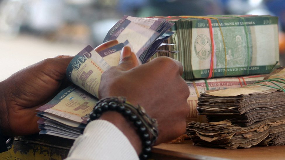 Руки считают деньги в Либерии