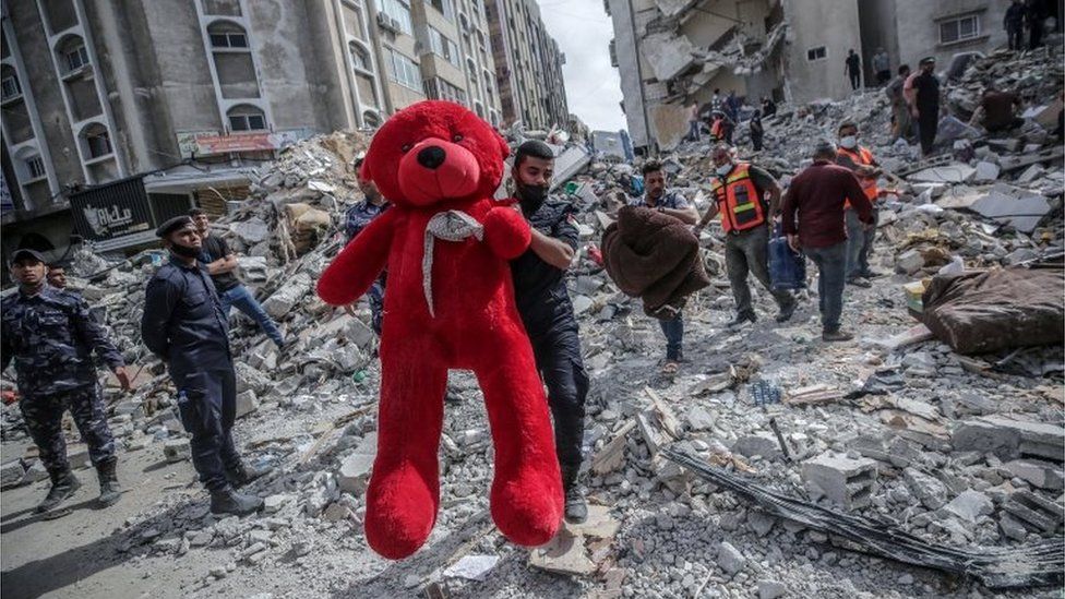 عامل انقاذ في غزة يحمل دمية أخرجت من بين أنقاض المباني المدمرة