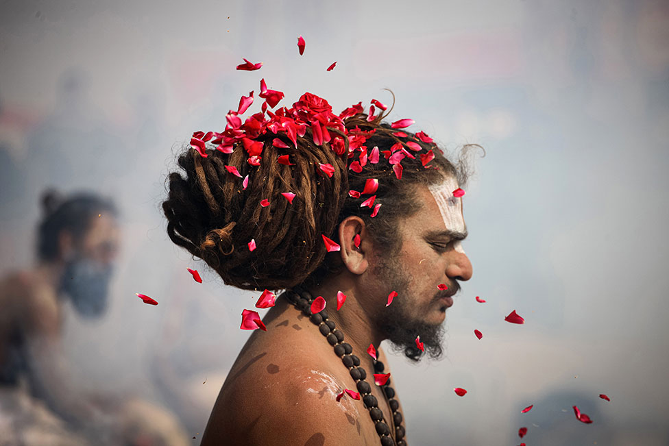 يبتلات الأزهار تهطل على رمز ديني هندي (سادو)في مدينة ألله اباد في الهند.