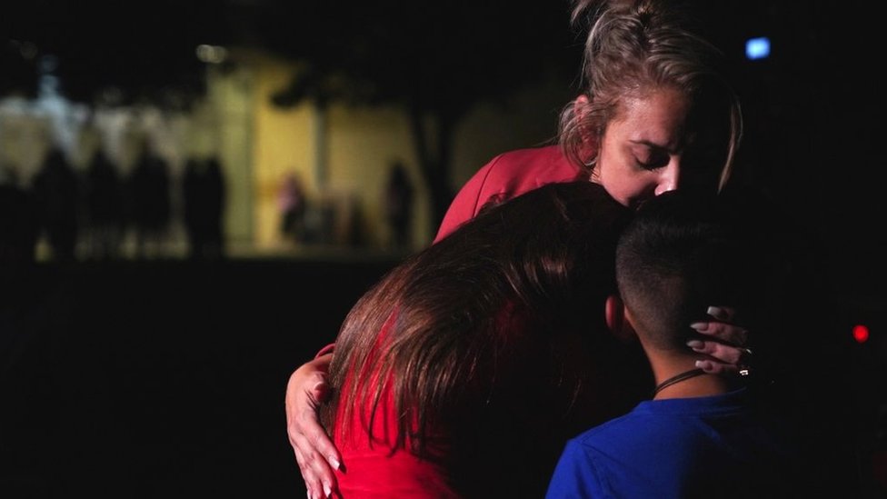Familias se abrazan frente al Centro Cívico Willie de Leon, donde se ofrecerá asesoramiento por duelo en Uvalde, Texas