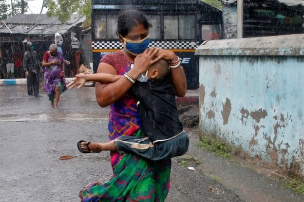 امرأة هندية تفر بطفلها من وجه إعصار أمفان