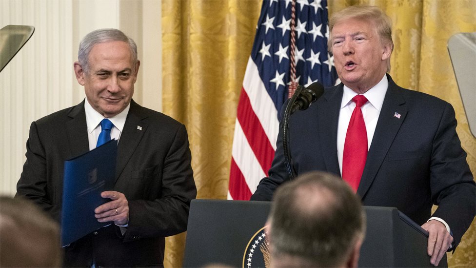 Премьер-министр Израиля Биньямин Нетаньяху улыбается, когда президент США Дональд Трамп представляет свой ближневосточный мирный план в Белом доме (28 января 2020 г.)