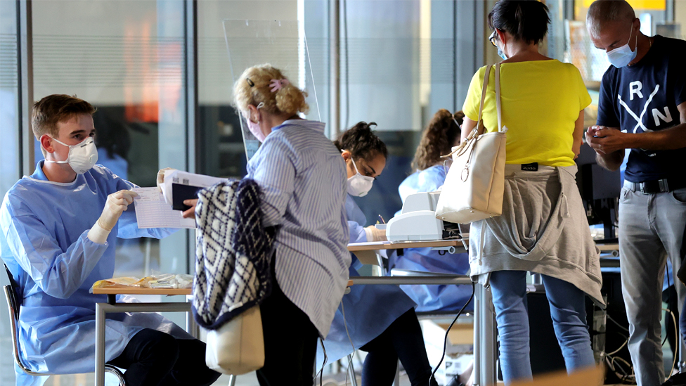 Travellers line up to be tested for Covid-19 at the airport in Dortmund, Germany