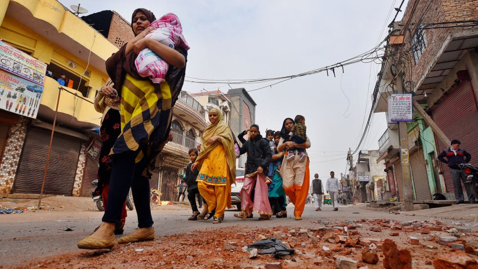 Люди покидают свои дома после насилия в общинах по поводу Закона о гражданстве (CAA) в районе Шив Вихар 27 февраля 2020 года в Нью-Дели, Индия
