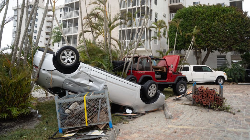 Un auto volcado luego del huracán Ian en Florida.