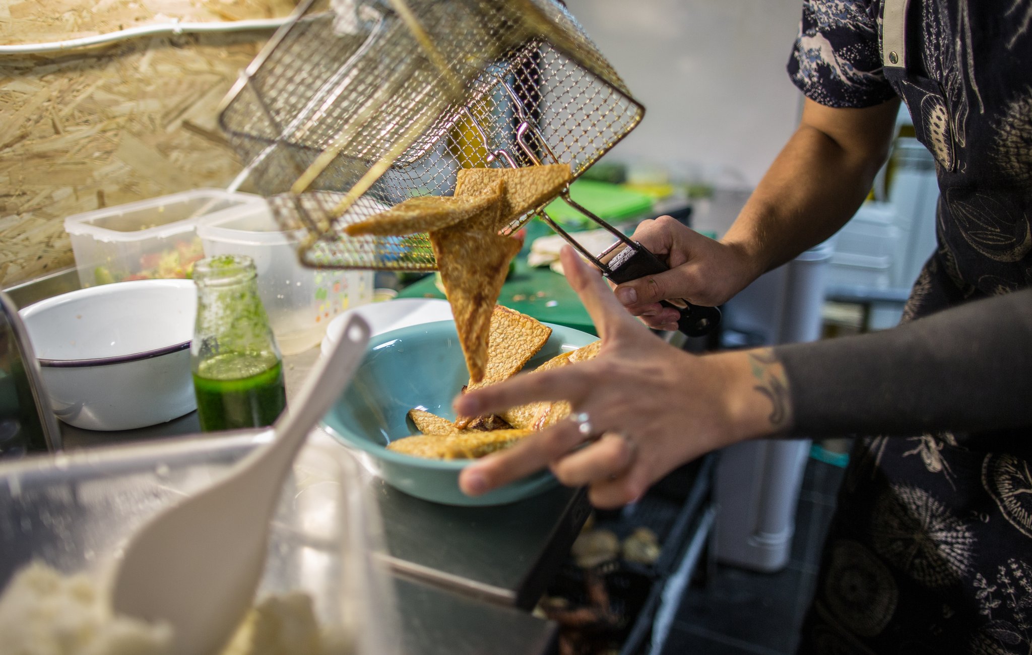 Iiuri pouring tempeh from the deep fryer into a bowl
