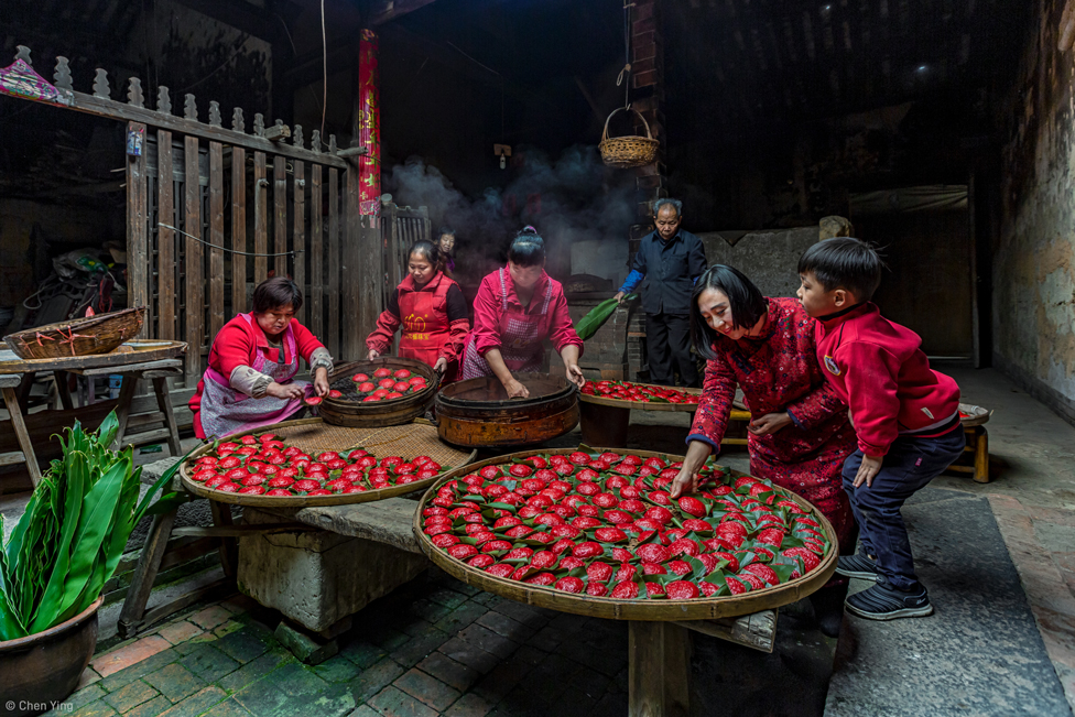 Una familia realizando dumplings rojos