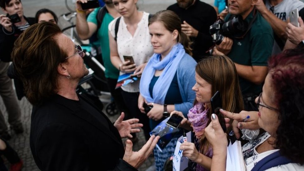 Певец ирландской рок-группы U2 разговаривает с поклонниками после визита к канцлеру Германии Ангеле Меркель (не на фото) перед канцелярией в Берлине, Германия, 28 августа 2018 г.