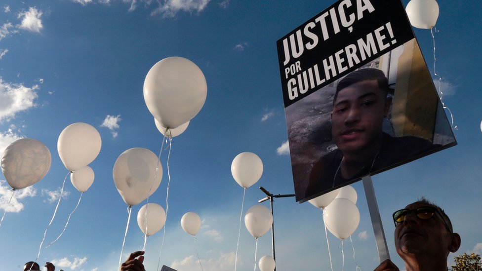 Протестующие держат табличку «Справедливость для Гильерме» после того, как 15-летний подросток был убит в Сан-Паулу в июне