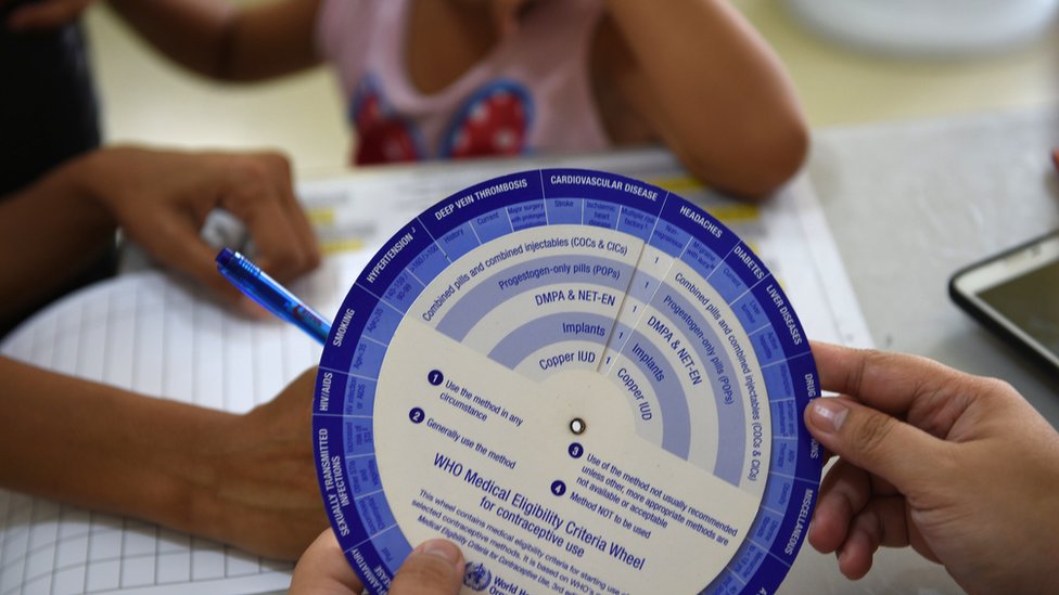 Una madre llena un formulario para un programa de anticoncepción en una barrio pobre de Manila, octubre 2017
