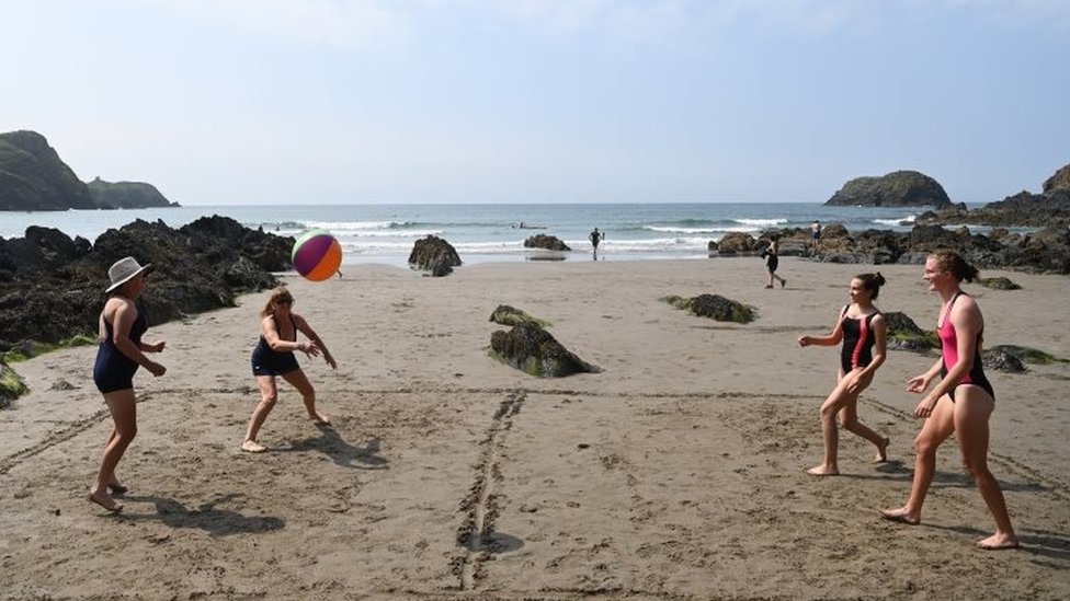 Любители пляжного отдыха играют в волейбол на пляже Трит Ллифн в Пембрукшире