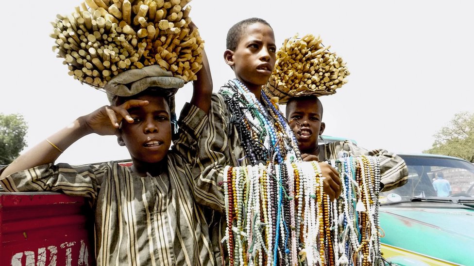 Three boys hawking wares in Nigeria