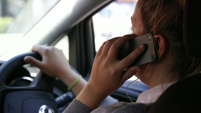 Female driver using hand-held mobile phone
