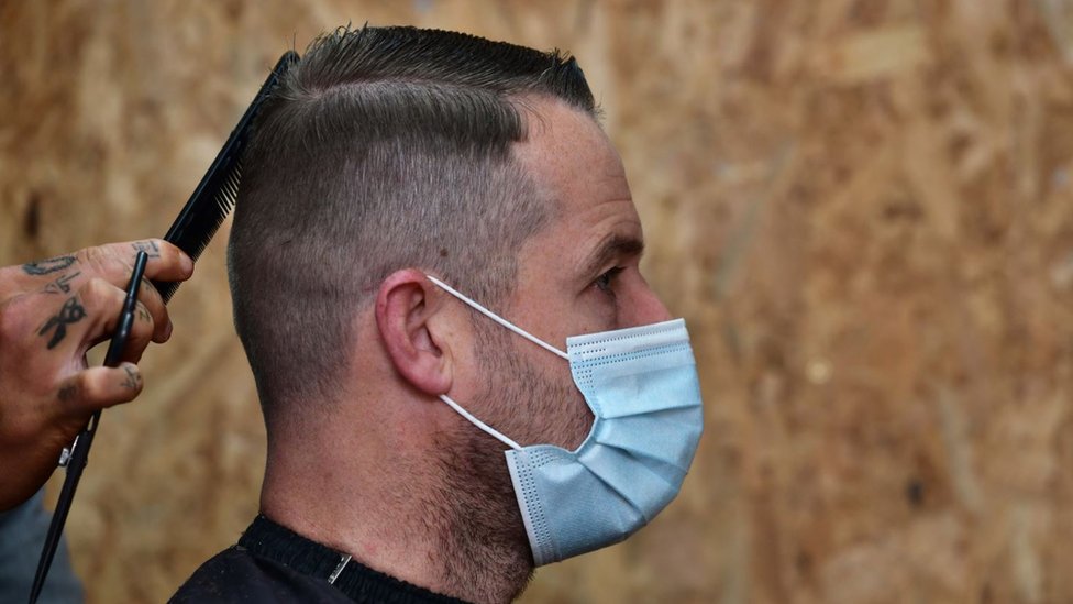 Man gets haircut while wearing face mask