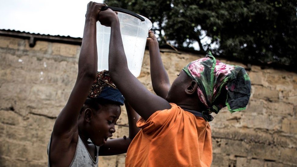 Mujeres con balde de agua en Kinshasa