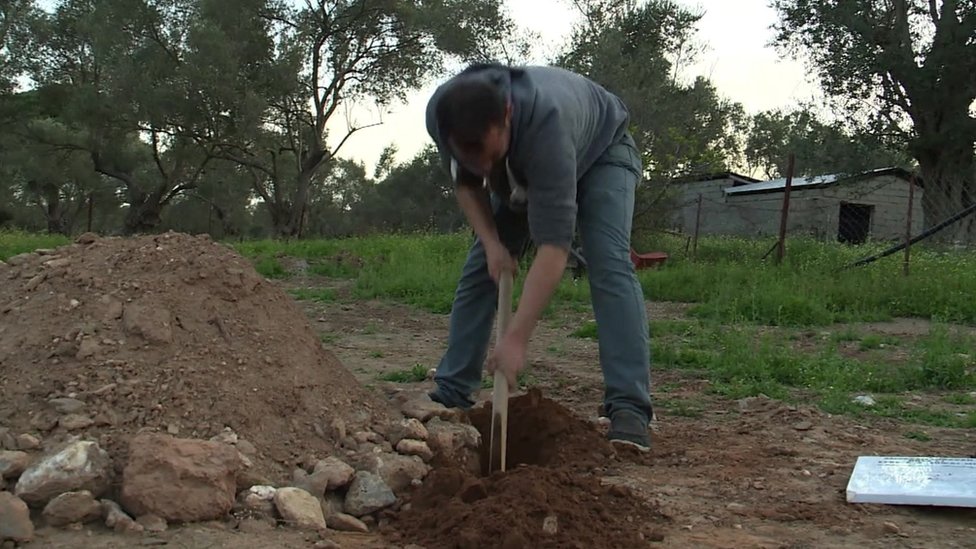 Mustafa Dawa digging a grave