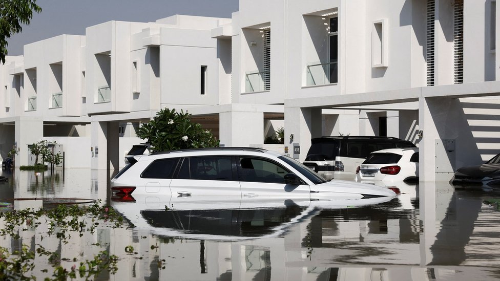 Cars lie partially submerged in water at a residential complex following heavy rainfall, in Dubai, United Arab Emirates, April 18, 2024