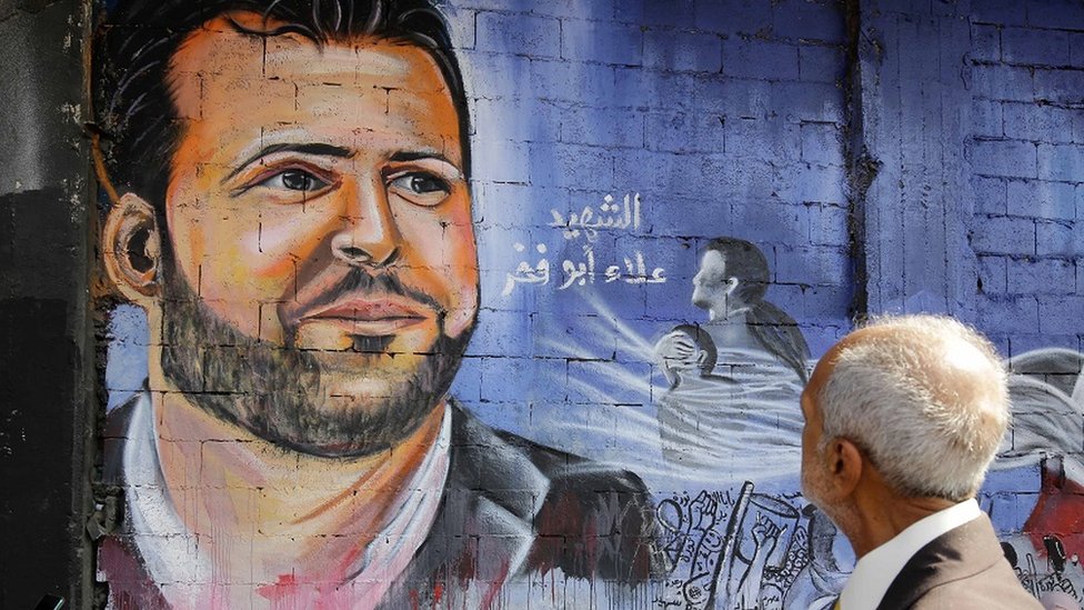 An elderly man looks at a mural in the Lebanese city of Tripoli, bearing a giant portrait of late Lebanese protester Alaa Abou Fakhr, who was shot dead south of Beirut on 12 November 2019.