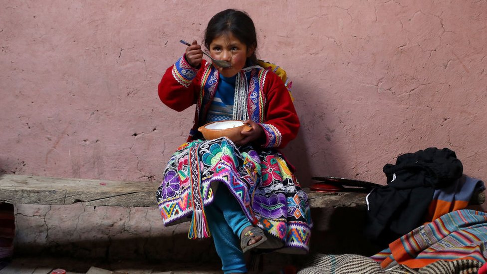 Peruvian girl eats dehydrated potato.