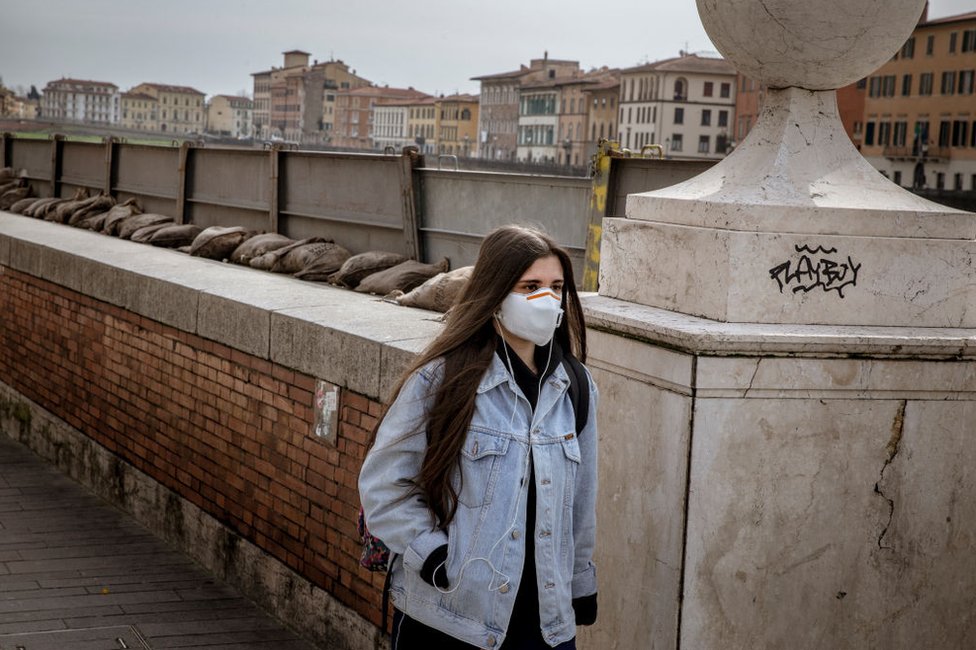 Mujer con mascarilla en Pisa, Italia.