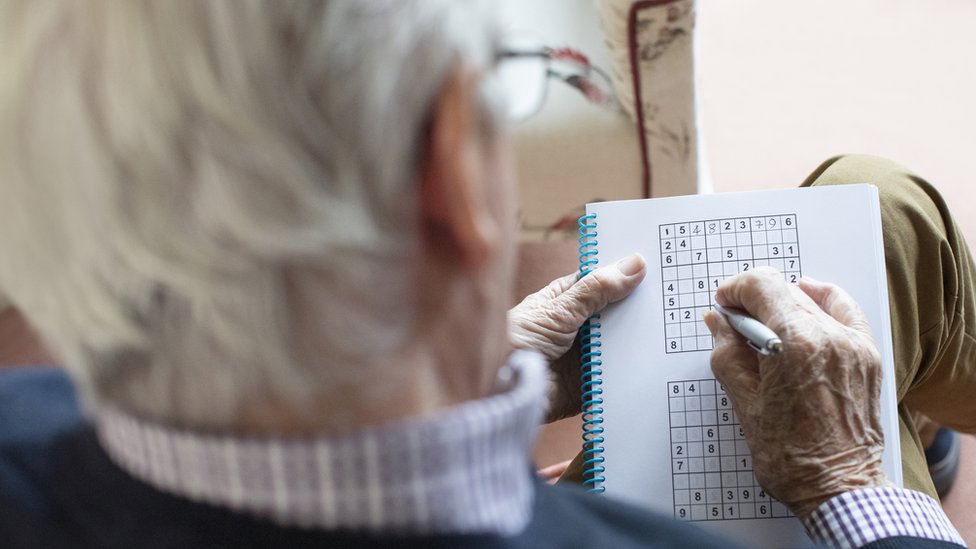 Anciano jugando sudoku.