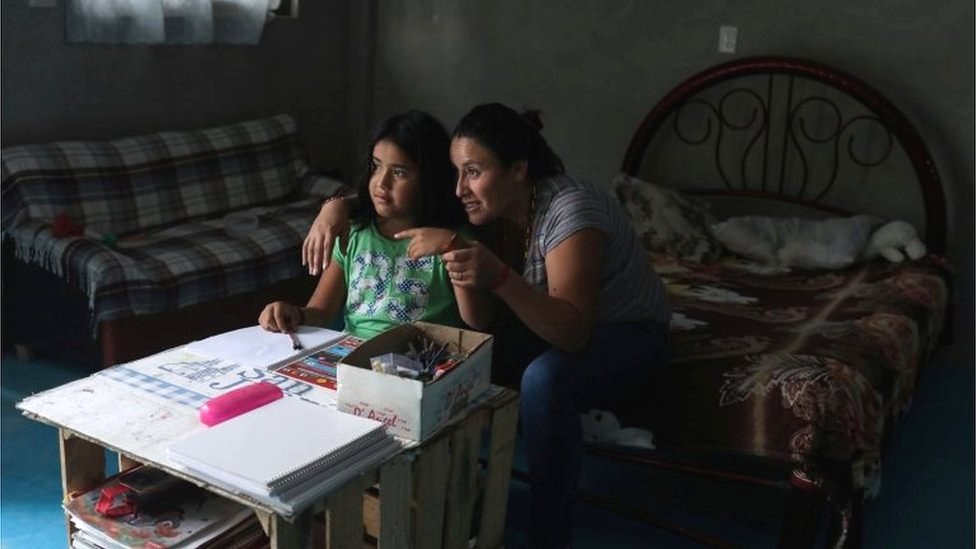 Karina Fuentes helps her daughter Julieta, 7, during a televised class as millions of students returned to classes virtually after schools were ordered into lockdown in March, due to the coronavirus disease (COVID-19) outbreak, in Chilcuautla, Hildalgo state, Mexico August 24, 2020.