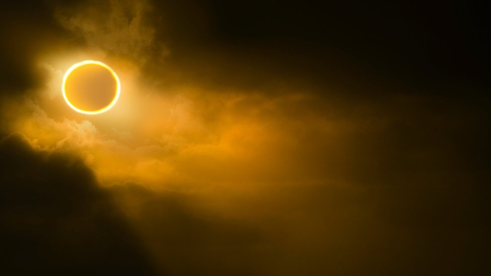 Eclipse solar em céu amarelado e nebuloso