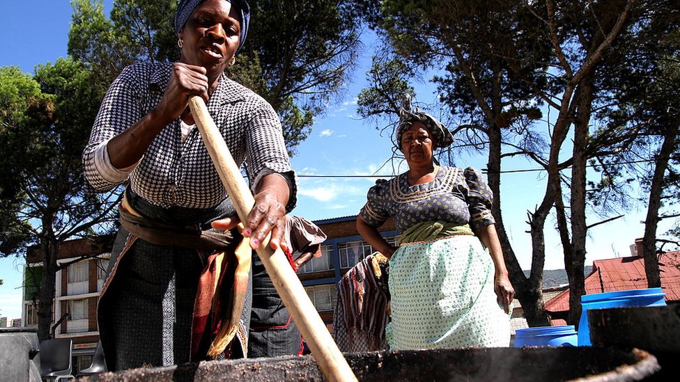 Южноафриканские женщины готовят большое количество традиционного пива (умкомботи) к 100-летию Африканского национального совета 4 января 2012 года в Блумфонтейне, Южная Африка.