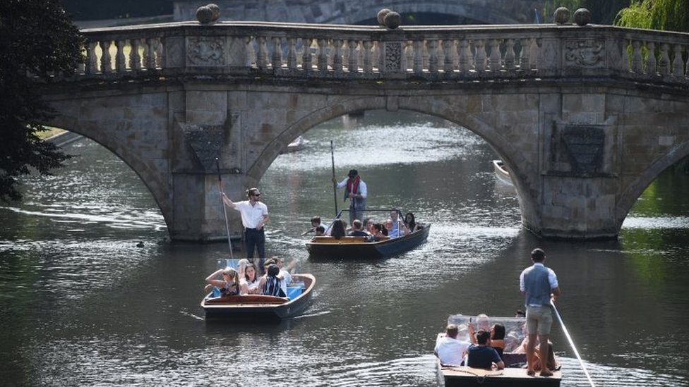 В жаркий день в Кембридже люди плывут по реке Кэм