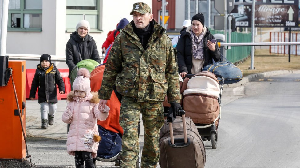 Soldado polaco ayudando a ucranianos que llegan a la frontera.
