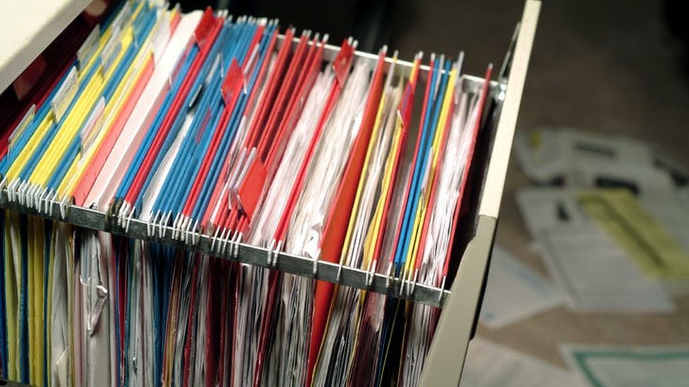 Folders with documents in a filing cabinet drawer