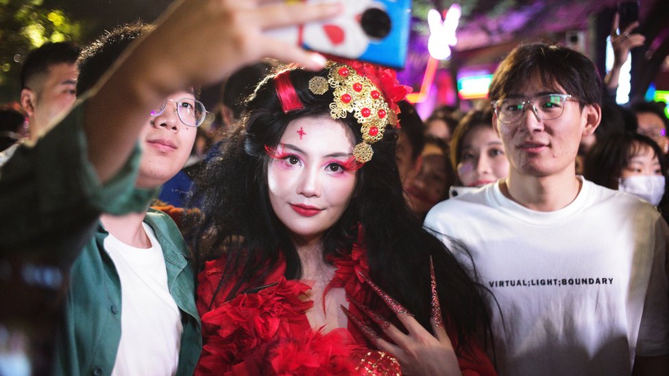萬聖節晚上上海民眾與cosplay裝扮女生合照（中新社圖片31/10/2023）
