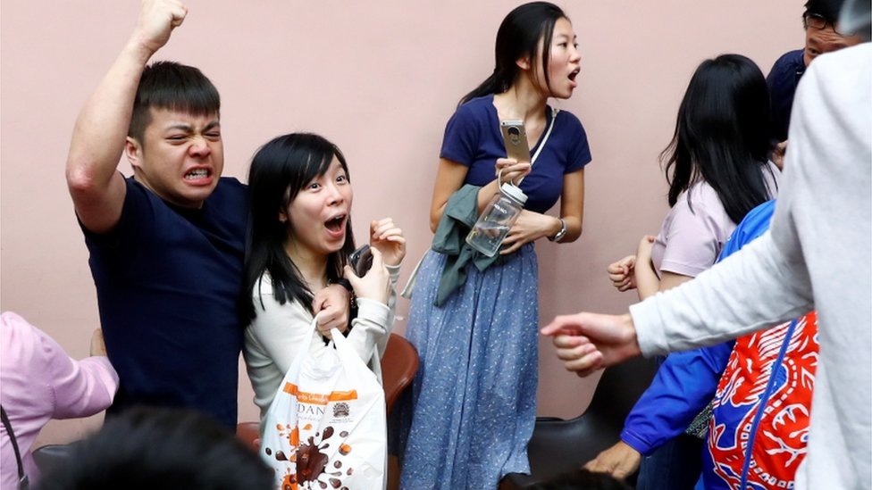 Сторонники местного кандидата Кельвина Лама празднуют победу в гонке в Гонконге