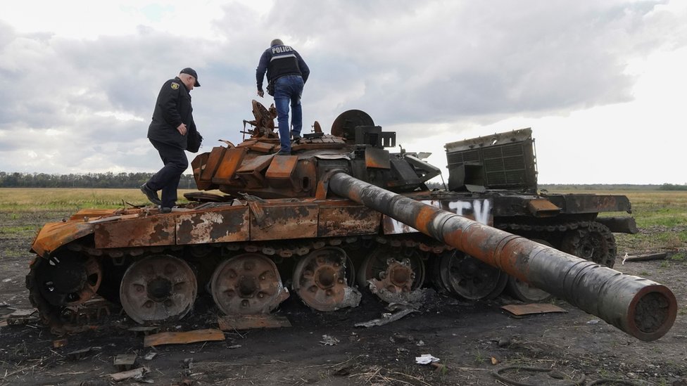Ukrainian police inspect a destroyed Russian tank in Kupiansk, Kharkiv region, 4 October