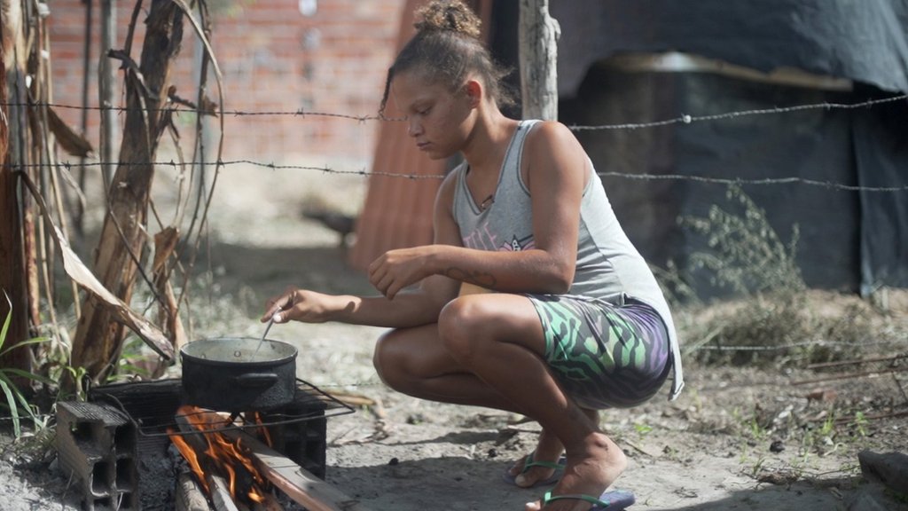 Jamile Carvalho cozinhando em um fogão improvisado