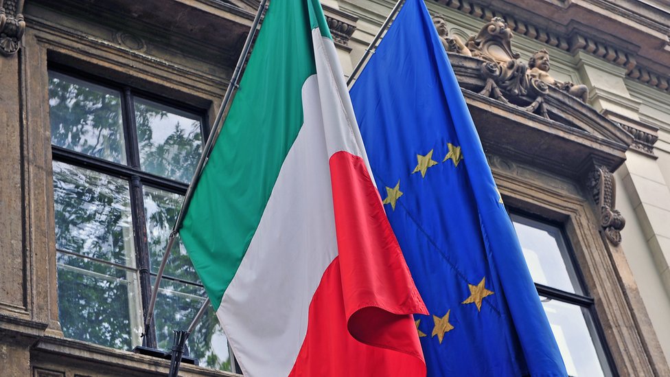 Banderas de Italia y de la Unión Europea delante de un edificio