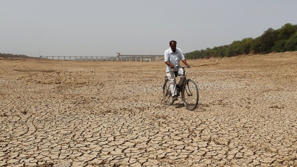 Индийский велосипедист едет по высохшему руслу реки Сабармати возле Сант-Саровара, водохранилища, расположенного в столице Гуджарата Гандхинагаре, примерно в 30 км. из Ахмедабада 1 мая 2019 года.