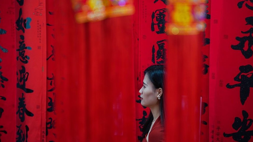 廣西南寧一名婦女在即將到來的中國農曆新年前購買紅燈籠和對聯裝飾