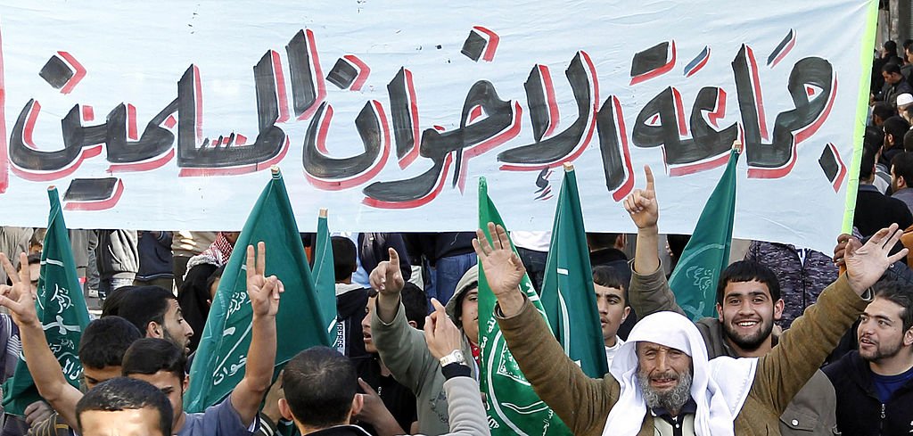 أنصار الإخوان المسلمين يرفعون لافتة كتب عليها جماعة الإخوان المسلمين.