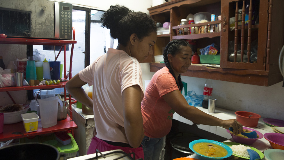 44-летняя Кусуэло Виллега Мендоса и ее дочь готовят колумбийское тушеное мясо Мондонго для подачи в ресторан, который они используют в доме, построенном Виллегой