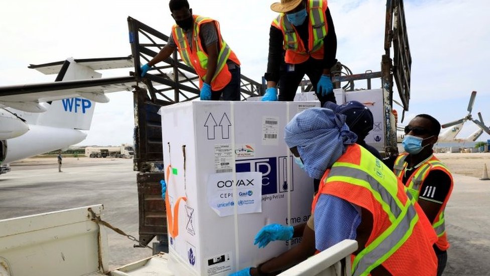 Workers offload AstraZeneca/Oxford vaccines under the COVAX scheme at the Aden Abdulle Osman Airport in Mogadishu, Somalia