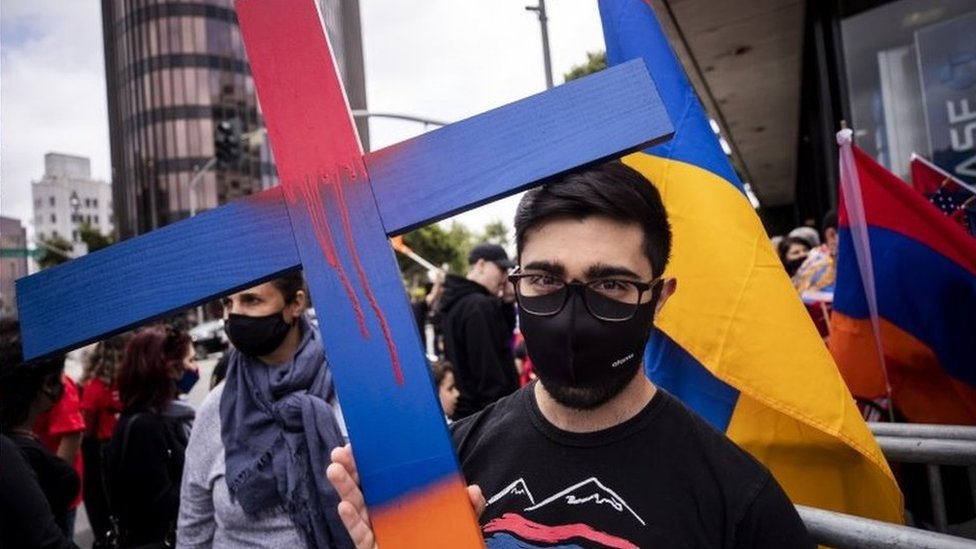 Manifestante com cartaz cruz