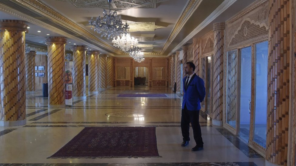 7 марта 2018 года - посыльный стоит в холле отеля Intercontinental в Кабуле.