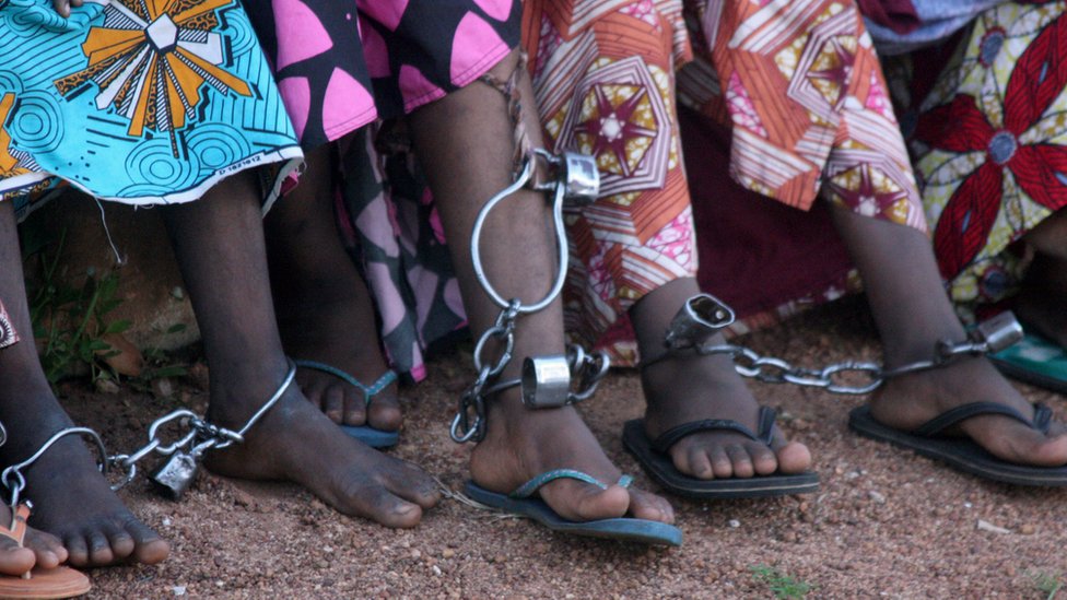 Mujeres en vestidos, encadenadas en Nigeria