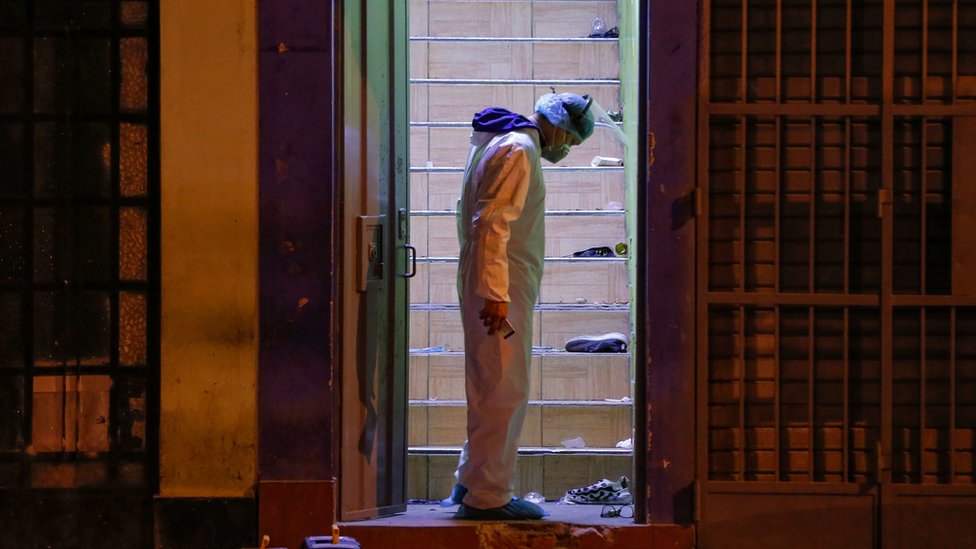 Следователь полиции стоит на месте, где 22 августа 2020 года в дверном проеме ночного клуба погибли 13 человек