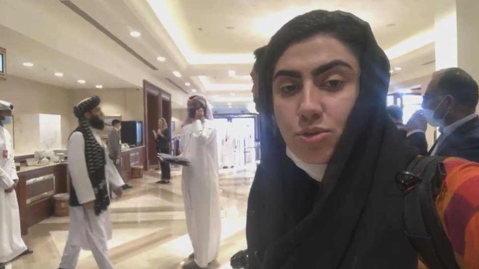 Shazia Haya taking a selfie in a Doha hotel with Taliban members in the background